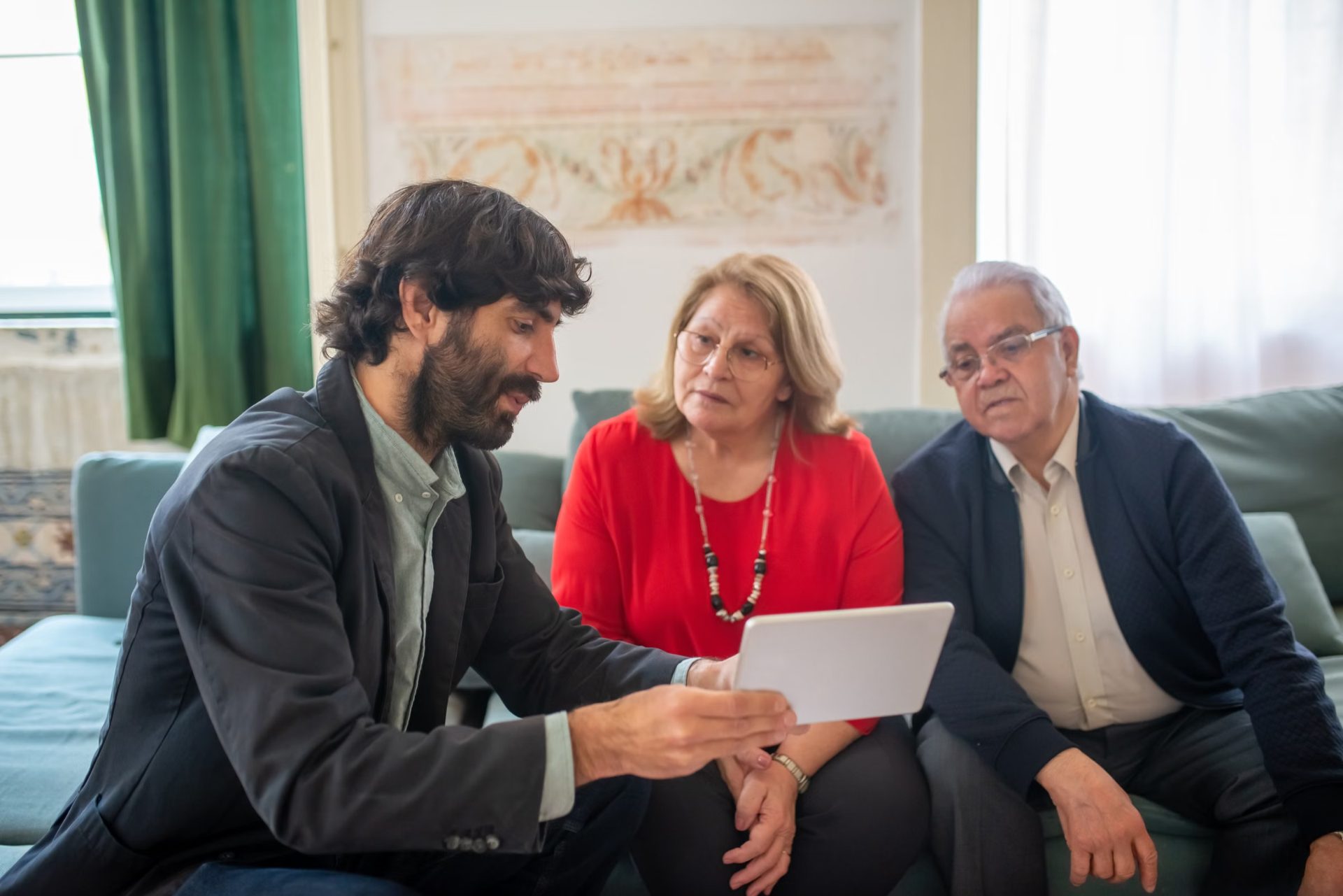 An insurance advisor showing a retired couple their options on a tablet