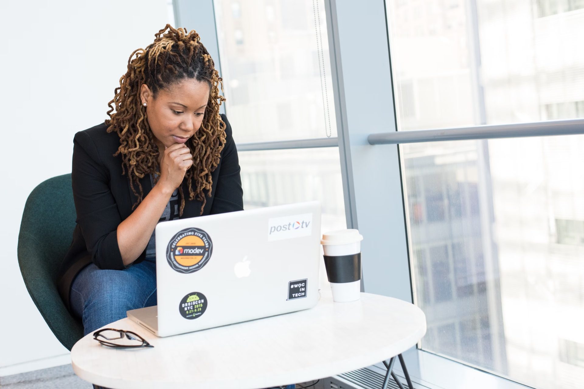 A professional reviewing results on a laptop by a window